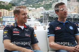 Sebastian Vettel (GER) Red Bull Racing with Sebastien Ogier (FRA) Rally Driver on the Red Bull Energy Station. 22.05.2013. Formula 1 World Championship, Rd 6, Monaco Grand Prix, Monte Carlo, Monaco, Preparation Day.