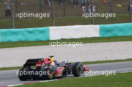 Sebastian Vettel (GER) Red Bull Racing RB9 and Romain Grosjean (FRA) Lotus F1 E21 battle for position. 24.03.2013. Formula 1 World Championship, Rd 2, Malaysian Grand Prix, Sepang, Malaysia, Sunday.