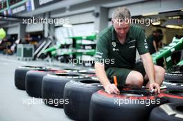 Caterham CT03 mechanic marks up Pirelli tyres. 19.09.2013. Formula 1 World Championship, Rd 13, Singapore Grand Prix, Singapore, Singapore, Preparation Day.