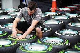 Mercedes AMG F1 mechanic with Pirelli tyres. 19.09.2013. Formula 1 World Championship, Rd 13, Singapore Grand Prix, Singapore, Singapore, Preparation Day.
