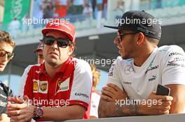 (L to R): Fernando Alonso (ESP) Ferrari with Lewis Hamilton (GBR) Mercedes AMG F1 on the drivers parade. 03.11.2013. Formula 1 World Championship, Rd 17, Abu Dhabi Grand Prix, Yas Marina Circuit, Abu Dhabi, Race Day.