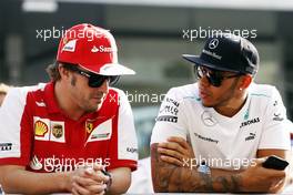 (L to R): Fernando Alonso (ESP) Ferrari with Lewis Hamilton (GBR) Mercedes AMG F1 on the drivers parade. 03.11.2013. Formula 1 World Championship, Rd 17, Abu Dhabi Grand Prix, Yas Marina Circuit, Abu Dhabi, Race Day.