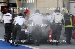 The smoking Sauber C33 of Adrian Sutil (GER) Sauber is pushed down the pit lane by mechanics. 01.03.2014. Formula One Testing, Bahrain Test Two, Day Three, Sakhir, Bahrain.