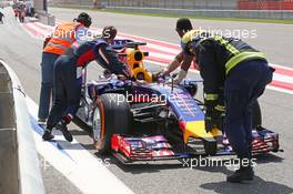 Sebastian Vettel (GER) helps return his Red Bull Racing RB10 back to the pits after stopping at the pit exit. 01.03.2014. Formula One Testing, Bahrain Test Two, Day Three, Sakhir, Bahrain.