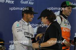 Race winner Lewis Hamilton (GBR) Mercedes AMG F1 on the podium with Brian Johnson (GBR) AC/DC Lead Singer. 06.04.2014. Formula 1 World Championship, Rd 3, Bahrain Grand Prix, Sakhir, Bahrain, Race Day.