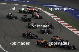 Sebastian Vettel (GER) Red Bull Racing RB10 and Kevin Magnussen (DEN) McLaren MP4-29 at the start of the race. 06.04.2014. Formula 1 World Championship, Rd 3, Bahrain Grand Prix, Sakhir, Bahrain, Race Day.