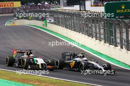 (L to R): Nico Hulkenberg (GER) Sahara Force India F1 VJM07 and Kevin Magnussen (DEN) McLaren MP4-29 battle for position. 09.11.2014. Formula 1 World Championship, Rd 18, Brazilian Grand Prix, Sao Paulo, Brazil, Race Day.