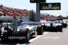 Daniel Ricciardo (AUS) Red Bull Racing RB10, Lewis Hamilton (GBR) Mercedes AMG F1 W05 and Nico Rosberg (GER) Mercedes AMG F1 W05 at the pit lane exit. 09.05.2014. Formula 1 World Championship, Rd 5, Spanish Grand Prix, Barcelona, Spain, Practice Day.