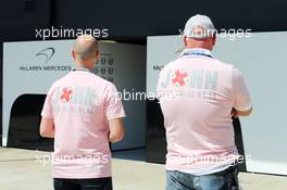 Fans in the paddock wear Pink for Papa clothing in memory of John Button (GBR), the late father of Jenson Button (GBR) McLaren. 04.07.2014. Formula 1 World Championship, Rd 9, British Grand Prix, Silverstone, England, Practice Day.