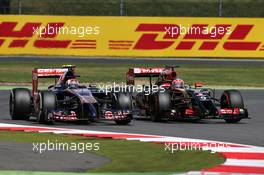 Daniil Kvyat (RUS) Scuderia Toro Rosso STR9 and Romain Grosjean (FRA) Lotus F1 E22 battle for position. 06.07.2014. Formula 1 World Championship, Rd 9, British Grand Prix, Silverstone, England, Race Day.