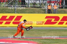 A marshal removes debris from the circuit. 06.07.2014. Formula 1 World Championship, Rd 9, British Grand Prix, Silverstone, England, Race Day.