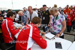 (L to R): Jules Bianchi (FRA) Marussia F1 Team and team mate Max Chilton (GBR) Marussia F1 Team sign autographs for the fans. 05.07.2014. Formula 1 World Championship, Rd 9, British Grand Prix, Silverstone, England, Qualifying Day.