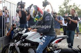 Lewis Hamilton (GBR) Mercedes AMG F1 arrives at the circuit on a motorbike. 07.09.2014. Formula 1 World Championship, Rd 13, Italian Grand Prix, Monza, Italy, Race Day.