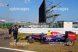 The damaged Red Bull Racing RB10 of Daniel Ricciardo (AUS), after he crashed during FP2, is is recovered back to the pits by Red Bull Racing mechanics. 03.10.2014. Formula 1 World Championship, Rd 15, Japanese Grand Prix, Suzuka, Japan, Practice Day.
