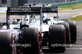 Nico Rosberg (GER) Mercedes AMG F1 W05, Lewis Hamilton (GBR) Mercedes AMG F1 W05, and Sebastian Vettel (GER) Red Bull Racing RB10 at the end of the pit lane. 03.10.2014. Formula 1 World Championship, Rd 15, Japanese Grand Prix, Suzuka, Japan, Practice Day.