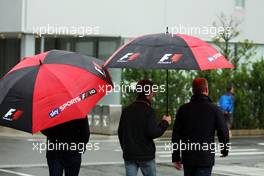 Anthony Davidson (GBR) Sky Sports F1 Presenter (Centre) and Johnny Herbert (GBR) Sky Sports F1 Presenter (Right) under umbrellas in a wet and rainy paddock. 05.10.2014. Formula 1 World Championship, Rd 15, Japanese Grand Prix, Suzuka, Japan, Race Day.