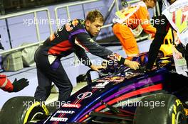 Sebastian Vettel (GER) Red Bull Racing RB10 stops at the end of FP1 and helps push the car back to the pits. 19.09.2014. Formula 1 World Championship, Rd 14, Singapore Grand Prix, Singapore, Singapore, Practice Day.