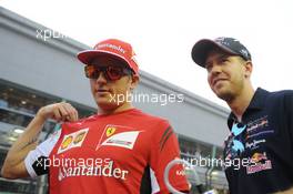 (L to R): Kimi Raikkonen (FIN) Ferrari with Sebastian Vettel (GER) Red Bull Racing on the drivers parade. 21.09.2014. Formula 1 World Championship, Rd 14, Singapore Grand Prix, Singapore, Singapore, Race Day.