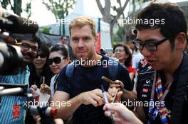 Sebastian Vettel (GER) Red Bull Racing signs autographs for the fans. 21.09.2014. Formula 1 World Championship, Rd 14, Singapore Grand Prix, Singapore, Singapore, Race Day.