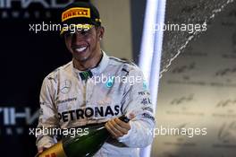 Race winner and World Championship Lewis Hamilton (GBR) Mercedes AMG F1 celebrates on the podium. 23.11.2014. Formula 1 World Championship, Rd 19, Abu Dhabi Grand Prix, Yas Marina Circuit, Abu Dhabi, Race Day.
