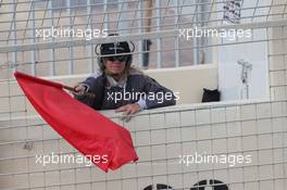 A marshal waves a red flag. 25.11.2014. Formula 1 Testing, Day One, Yas Marina Circuit, Abu Dhabi, Tuesday.