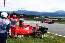 Sebastian Vettel (GER) Ferrari SF15-T passes the damaged Ferrari SF15-T of team mate Kimi Raikkonen (FIN) Ferrari. 21.06.2015. Formula 1 World Championship, Rd 8, Austrian Grand Prix, Spielberg, Austria, Race Day.