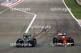 (L to R): Nico Rosberg (GER) Mercedes AMG F1 W06 and Sebastian Vettel (GER) Ferrari SF15-T battle for position. 19.04.2015. Formula 1 World Championship, Rd 4, Bahrain Grand Prix, Sakhir, Bahrain, Race Day.