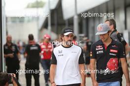 (L to R): Fernando Alonso (ESP) McLaren with Carlos Sainz Jr (ESP) Scuderia Toro Rosso. 03.07.2015. Formula 1 World Championship, Rd 9, British Grand Prix, Silverstone, England, Practice Day.