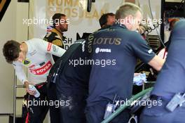 Romain Grosjean (FRA) Lotus F1 Team helps clean his Lotus F1 E23 after a trip through the gravel trap. 03.07.2015. Formula 1 World Championship, Rd 9, British Grand Prix, Silverstone, England, Practice Day.