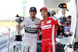 (L to R): Race winner Lewis Hamilton (GBR) Mercedes AMG F1 celebrates on the podium with third placed Sebastian Vettel (GER) Ferrari. 27.09.2015. Formula 1 World Championship, Rd 14, Japanese Grand Prix, Suzuka, Japan, Race Day.