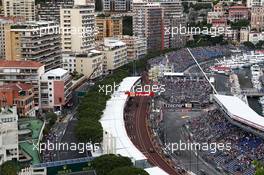 Romain Grosjean (FRA) Lotus F1 E23 in the pits and Pastor Maldonado (VEN) Lotus F1 E23 on the circuit. 23.05.2015. Formula 1 World Championship, Rd 6, Monaco Grand Prix, Monte Carlo, Monaco, Qualifying Day