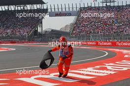 A marshal removes the tyre carcass of Sebastian Vettel (GER) Ferrari. 01.11.2015. Formula 1 World Championship, Rd 17, Mexican Grand Prix, Mexixo City, Mexico, Race Day.
