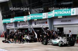 Nico Rosberg (GER) Mercedes AMG F1 W06 and Lewis Hamilton (GBR) Mercedes AMG F1 W06 in the pits. 28.03.2015. Formula 1 World Championship, Rd 2, Malaysian Grand Prix, Sepang, Malaysia, Saturday.