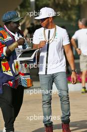 Lewis Hamilton (GBR) Mercedes AMG F1 with Mr Moko (SEN) Crown Hearts Jewelry. 26.11.2015. Formula 1 World Championship, Rd 19, Abu Dhabi Grand Prix, Yas Marina Circuit, Abu Dhabi, Preparation Day.