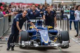 The Sauber C34 of Felipe Nasr (BRA) Sauber F1 Team is pushed by mechanics down the pit lane. 22.10.2015. Formula 1 World Championship, Rd 16, United States Grand Prix, Austin, Texas, USA, Preparation Day.
