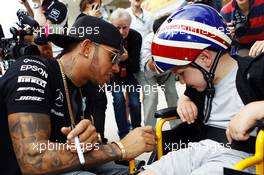 Lewis Hamilton (GBR) Mercedes AMG F1 with a young fan. 22.10.2015. Formula 1 World Championship, Rd 16, United States Grand Prix, Austin, Texas, USA, Preparation Day.