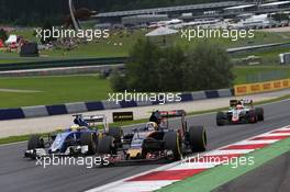 Carlos Sainz Jr (ESP) Scuderia Toro Rosso STR11 and Marcus Ericsson (SWE) Sauber C35. 03.07.2016. Formula 1 World Championship, Rd 9, Austrian Grand Prix, Spielberg, Austria, Race Day.