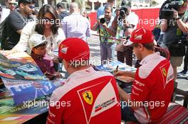 (L to R): Kimi Raikkonen (FIN) Ferrari and Sebastian Vettel (GER) Ferrari sign autographs for the fans. 02.04.2016. Formula 1 World Championship, Rd 2, Bahrain Grand Prix, Sakhir, Bahrain, Qualifying Day.