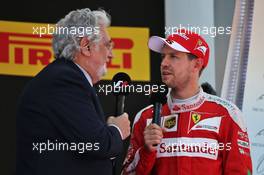 Sebastian Vettel (GER) Ferrari on the podium with Placido Domingo (ESP) Opera Singer. 15.05.2016. Formula 1 World Championship, Rd 5, Spanish Grand Prix, Barcelona, Spain, Race Day.