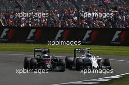 Fernando Alonso (ESP) McLaren Honda F1 Team MP4-31 and Valtteri Bottas (FIN) Williams Martini Racing FW38. 10.07.2016. Formula 1 World Championship, Rd 10, British Grand Prix, Silverstone, England, Race Day.