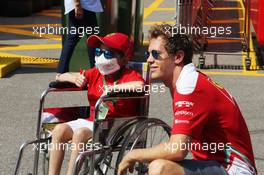 Sebastian Vettel (GER) Ferrari with a young fan. 01.09.2016. Formula 1 World Championship, Rd 14, Italian Grand Prix, Monza, Italy, Preparation Day.