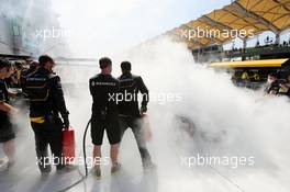 The Renault Sport F1 Team RS16 of Kevin Magnussen (DEN) is tended to by marshals and mechanics after it caught fire in the pits in the first practice session. 30.09.2016. Formula 1 World Championship, Rd 16, Malaysian Grand Prix, Sepang, Malaysia, Friday.