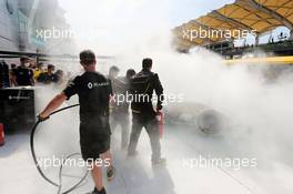 The Renault Sport F1 Team RS16 of Kevin Magnussen (DEN) is tended to by marshals and mechanics after it caught fire in the pits in the first practice session. 30.09.2016. Formula 1 World Championship, Rd 16, Malaysian Grand Prix, Sepang, Malaysia, Friday.