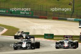 (L to R): Fernando Alonso (ESP) McLaren MP4-31 and Romain Grosjean (FRA) Haas F1 Team VF-16 battle for position. 02.10.2016. Formula 1 World Championship, Rd 16, Malaysian Grand Prix, Sepang, Malaysia, Sunday.