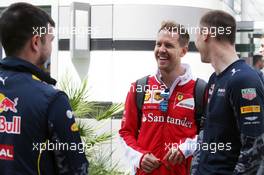 Sebastian Vettel (GER) Ferrari with members of Red Bull Racing. 30.04.2016. Formula 1 World Championship, Rd 4, Russian Grand Prix, Sochi Autodrom, Sochi, Russia, Qualifying Day.
