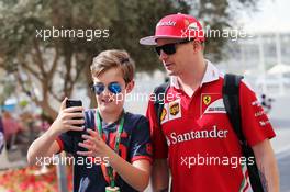 Kimi Raikkonen (FIN) Ferrari with a young fan. 25.11.2016. Formula 1 World Championship, Rd 21, Abu Dhabi Grand Prix, Yas Marina Circuit, Abu Dhabi, Practice Day.