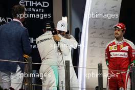 The podium (L to R): World Champion Nico Rosberg (GER) Mercedes AMG F1 shakes hands with team mate and race winner Lewis Hamilton (GBR) Mercedes AMG F1. 27.11.2016. Formula 1 World Championship, Rd 21, Abu Dhabi Grand Prix, Yas Marina Circuit, Abu Dhabi, Race Day.