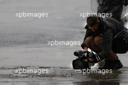 A cameraman films the flooding pit lane. 06.10.2017. Formula 1 World Championship, Rd 16, Japanese Grand Prix, Suzuka, Japan, Practice Day.