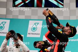 Daniel Ricciardo (AUS) Red Bull Racing celebrates his third with the champagne on the podium (Right) with Lewis Hamilton (GBR) Mercedes AMG F1 (Left). 01.10.2017. Formula 1 World Championship, Rd 15, Malaysian Grand Prix, Sepang, Malaysia, Sunday.