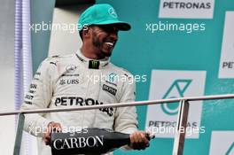 Lewis Hamilton (GBR) Mercedes AMG F1 celebrates his second position with the champagne on the podium. 01.10.2017. Formula 1 World Championship, Rd 15, Malaysian Grand Prix, Sepang, Malaysia, Sunday.